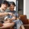 a woman and a man playing video games on a couch